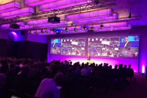 Stage setting with video walls and lighting in conference room with audience