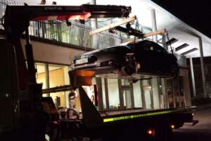 Tesla car hoisted to event venue at night
